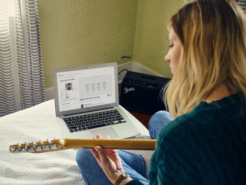 Guitar student learning from laptop